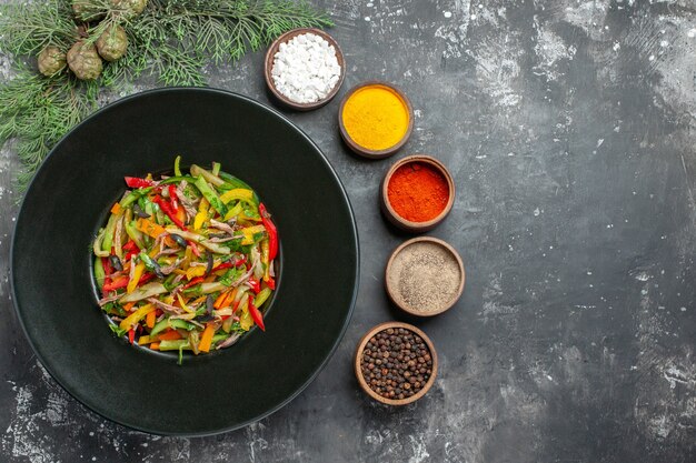 Bovenaanzicht van smakelijke groentesalade op donkere ondergrond