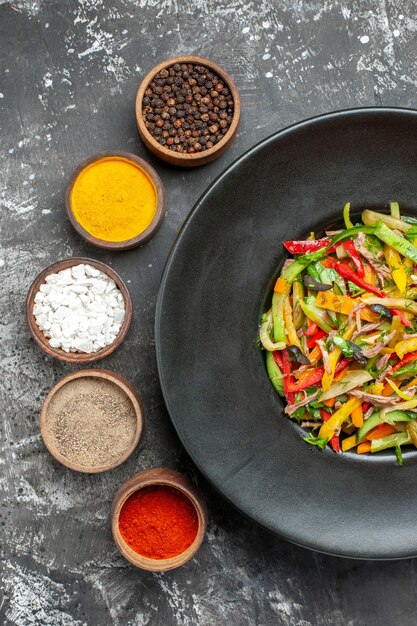 Bovenaanzicht van smakelijke groentesalade op donkere ondergrond