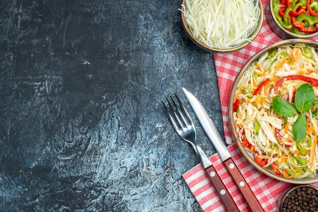 Bovenaanzicht van smakelijke groentesalade op donkere ondergrond