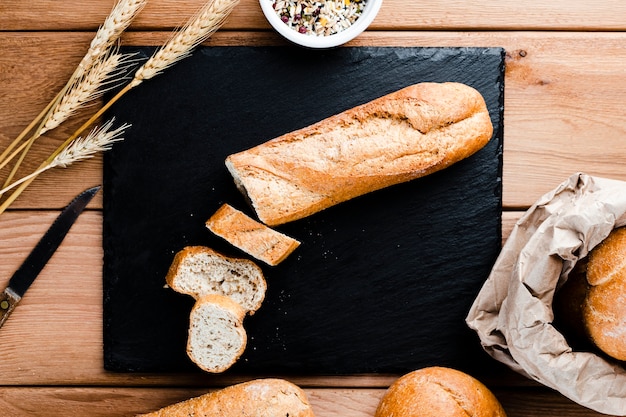 Bovenaanzicht van sneetjes en brood op woden tafel