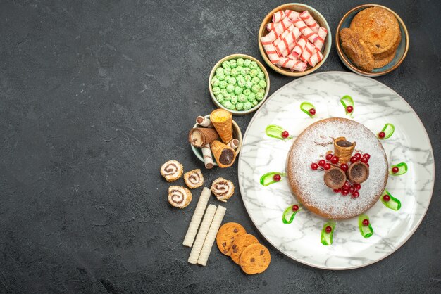 Bovenaanzicht van snoep een cake met bessen groene saus koekjes snoepjes