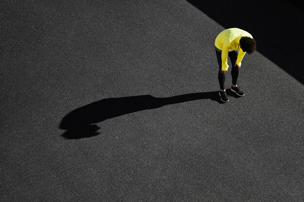 Bovenaanzicht van sportman die een pauze neemt van de training