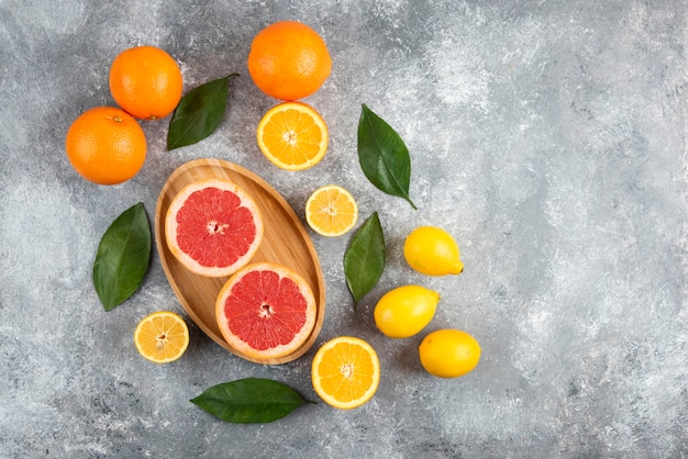 Bovenaanzicht van stapel vers fruit over grijze tafel.