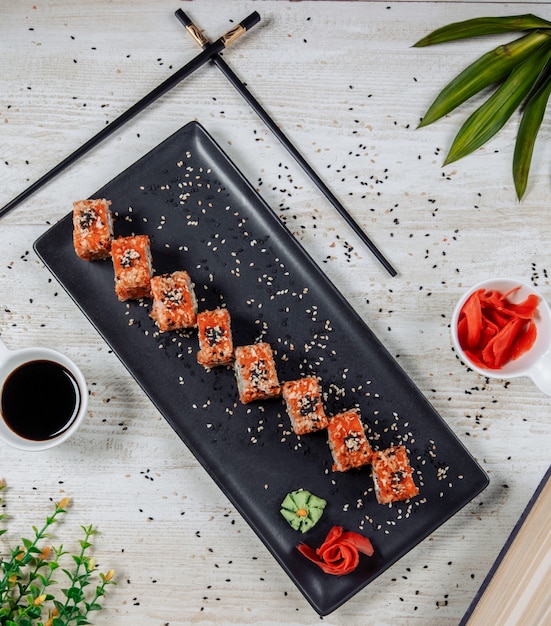 Bovenaanzicht van sushi rolletjes met rode tobiko en sesam