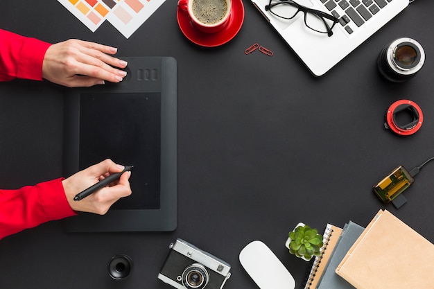 Gratis foto bovenaanzicht van tekenblok met handen op het bureau