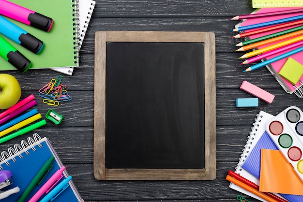 Bovenaanzicht van terug naar school briefpapier met kleurrijke potloden en schoolbord