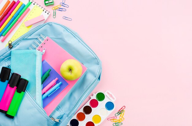 Bovenaanzicht van terug naar school essentials met appel en rugzak