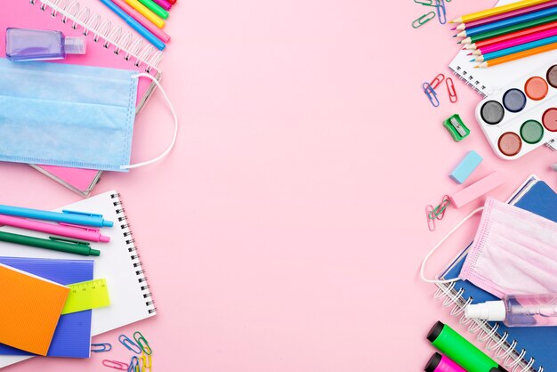 Bovenaanzicht van terug naar school essentials met medisch masker en potloden