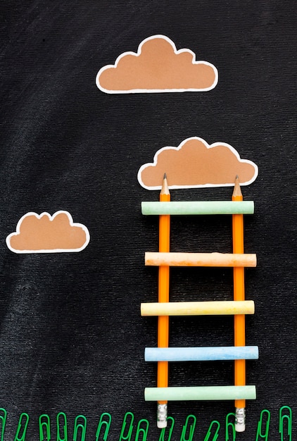 Gratis foto bovenaanzicht van terug naar school ladder met potloden en wolken