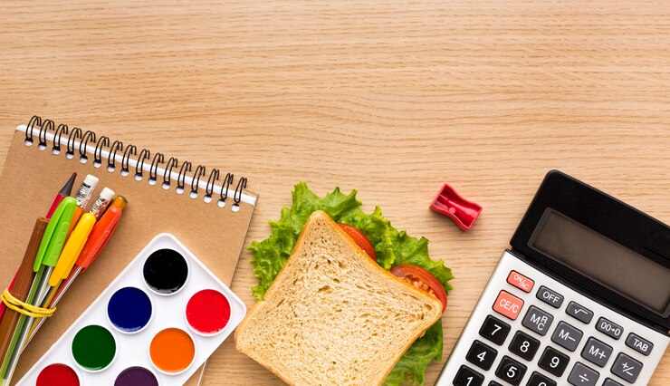 Gratis Foto bovenaanzicht van terug naar schoolbenodigdheden met rekenmachine en sandwich
