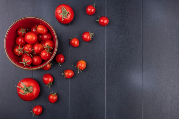 Gratis foto bovenaanzicht van tomaten in kom en op zwarte ondergrond