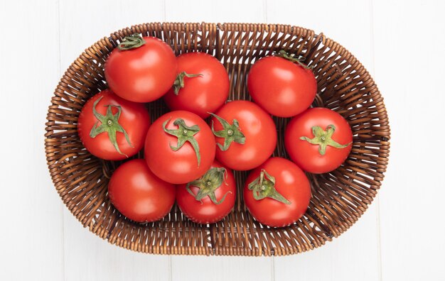 Bovenaanzicht van tomaten in mand op witte ondergrond