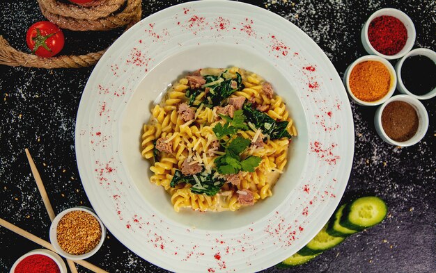 Bovenaanzicht van tonijnfusilli met spinazie en parmezaanse kaas