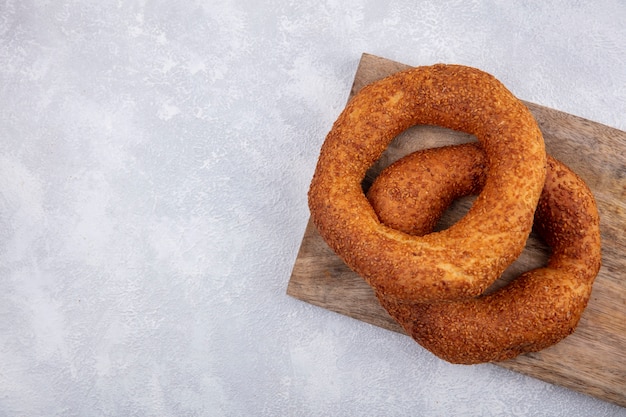 Bovenaanzicht van traditionele Turkse bagels op een houten keukenbord op een witte achtergrond met kopie ruimte