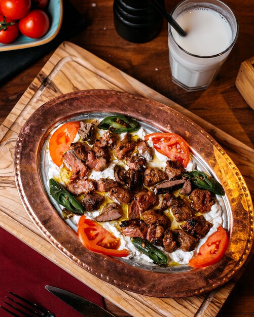 Bovenaanzicht van traditionele Turkse iskender doner met yoghurt op plaat