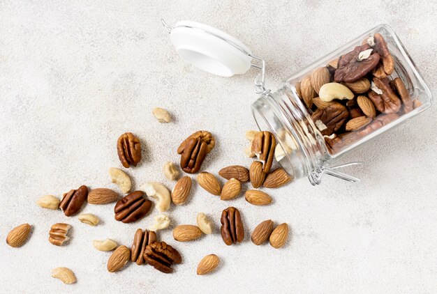Gratis foto bovenaanzicht van transparante pot met assortiment van noten