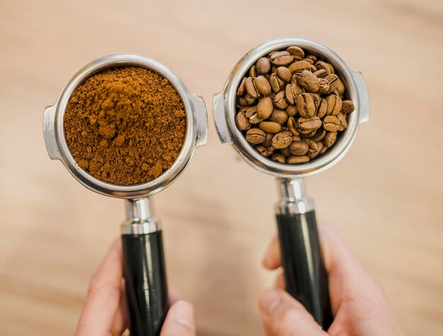 Bovenaanzicht van twee kopjes van koffiemachines gehouden door barista