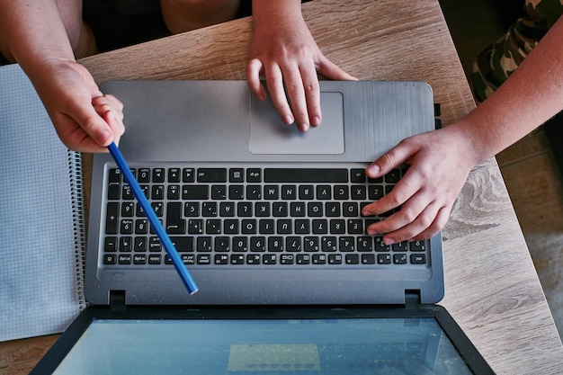 Bovenaanzicht van twee mannenhanden die het nieuwe project bespreken en met een laptop werken