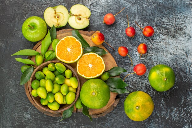 Bovenaanzicht van veraf fruit kersen appels citrusvruchten op de snijplank