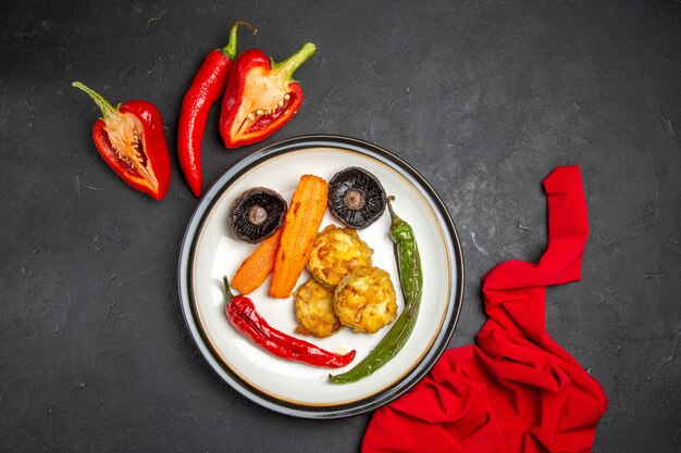 Bovenaanzicht van verafgelegen groenten rood tafelkleed paprika hete peper plaat van geroosterde groenten