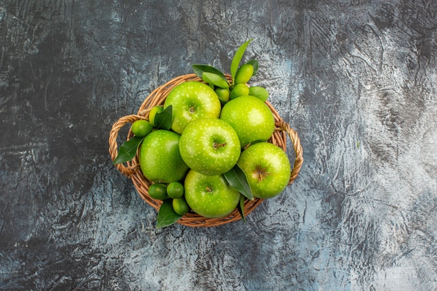 Bovenaanzicht van verre appels de smakelijke appels met bladeren in de mand