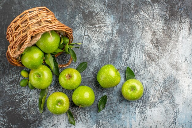 Bovenaanzicht van verre appels groene appels met bladeren in de houten mand