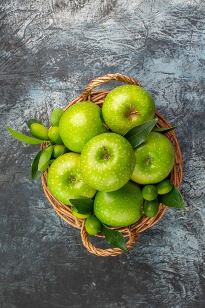 Bovenaanzicht van verre appels groene appels met bladeren in de mand