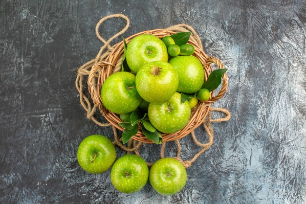 Bovenaanzicht van verre appels mand van de smakelijke appels met bladeren citrusvruchten touw