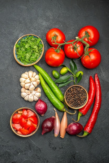 Bovenaanzicht van verre groenten tomaten met steeltjes hete pepers knoflook kruiden specerijen citrusvruchten