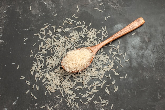 Gratis foto bovenaanzicht van verre rijst rijst in de lepel op de donkere tafel