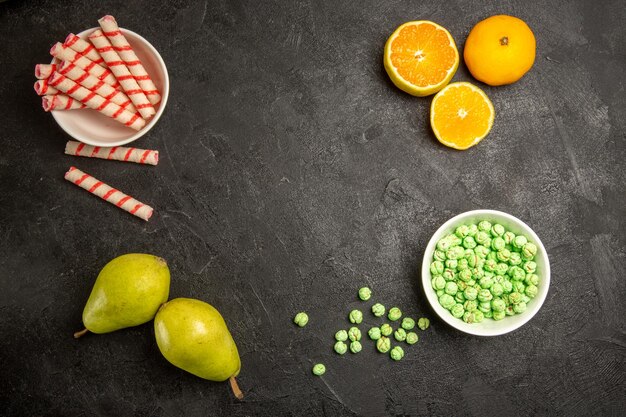 Bovenaanzicht van vers fruit met snoepjes op donkergrijs