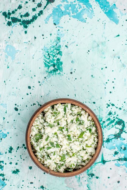 bovenaanzicht van vers gesneden koolsalade met greens in bruine kom op helderblauwe, groene de versheidssnack van de voedselgroente salade