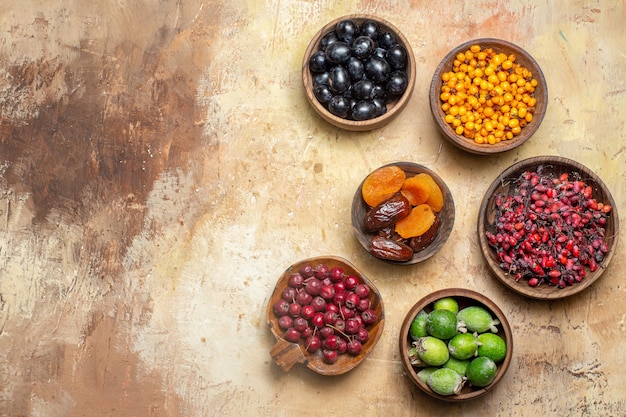 Gratis foto bovenaanzicht van vers verschillende soorten fruit in kleine bruine potten
