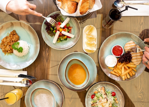 Bovenaanzicht van verschillende platen van voedsel fo diner groente salade met fetacheese rijst gegrilde kip met frietjes