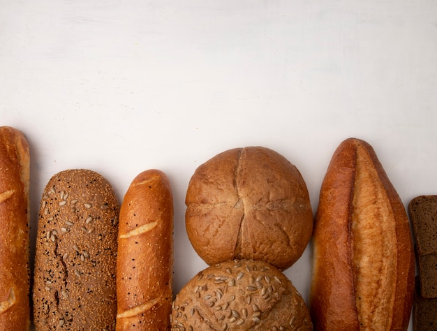 Bovenaanzicht van verschillende soorten brood als stokbrood rogge op witte achtergrond met kopie ruimte