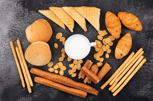 Bovenaanzicht van verschillende soorten brood zoals crackers, toast, croissants en melk