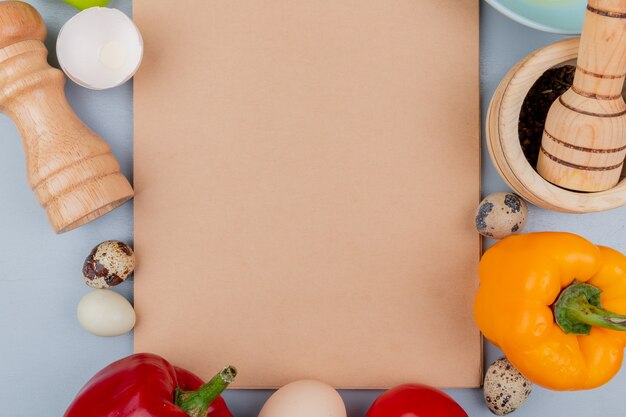 Bovenaanzicht van verschillende soorten eieren zoals kip en kwarteleitjes met paprika op een witte achtergrond met kopie ruimte