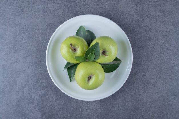 Bovenaanzicht van verse biologische groene appels op witte plaat