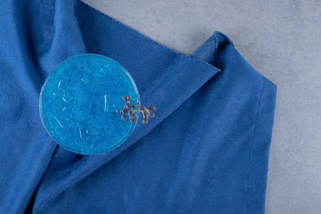 Bovenaanzicht van verse blauwe cocktail op blauw katoenen servet