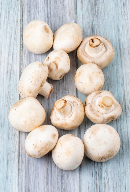 Bovenaanzicht van verse champignons champignon geïsoleerd op houten rustieke achtergrond