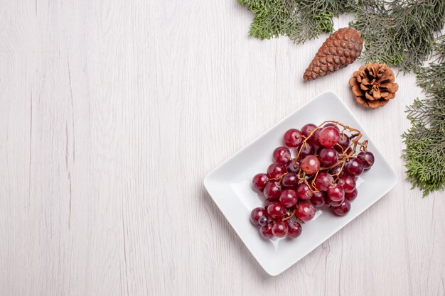 Bovenaanzicht van verse druiven in plaat op witte tafel