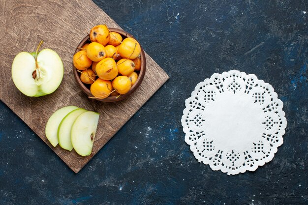 bovenaanzicht van verse groene appel half gesneden gesneden met zoete kersen op donker bureau, vers zacht rijp fruit