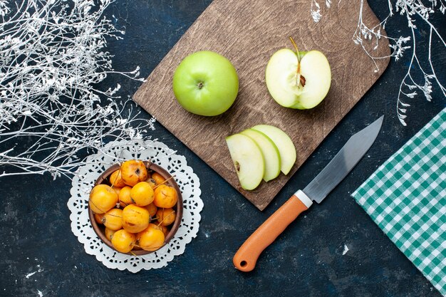 Bovenaanzicht van verse groene appels met zoete zachte kersen op blauw-donker bureau, fruit vers zacht voedsel vitamine