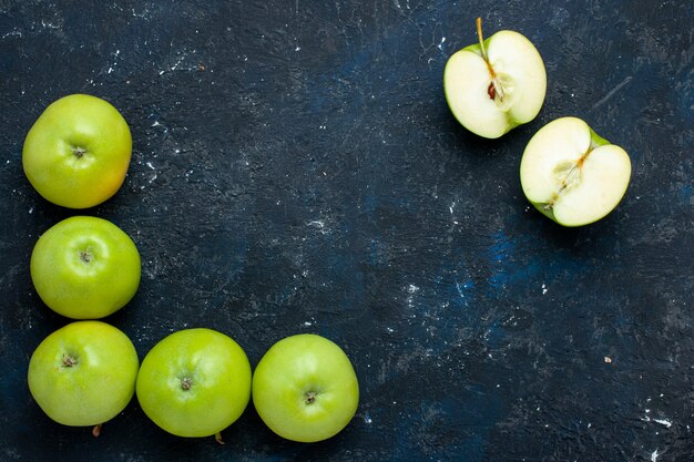 bovenaanzicht van verse groene appelsamenstelling met gesneden één bekleed op donker bureau, vers zacht rijp fruit