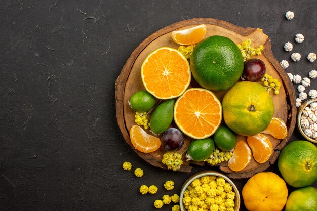 Bovenaanzicht van verse groene mandarijnen met feijoa's en snoepjes op dark