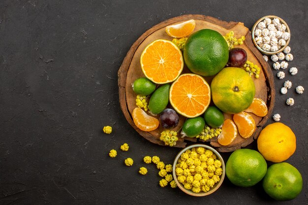 Bovenaanzicht van verse groene mandarijnen met feijoa's en snoepjes op dark