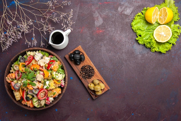 Bovenaanzicht van verse groente. salade met olijven en schijfjes citroen op zwart