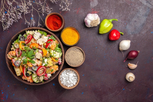 Bovenaanzicht van verse groente. salade met verschillende kruiden op zwart paars