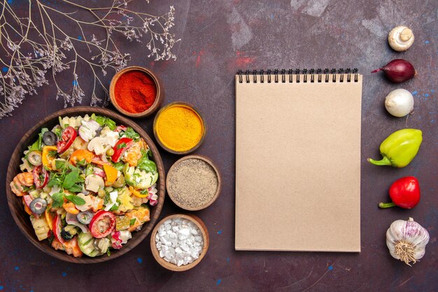 Bovenaanzicht van verse groentesalade met kruiden op zwart on