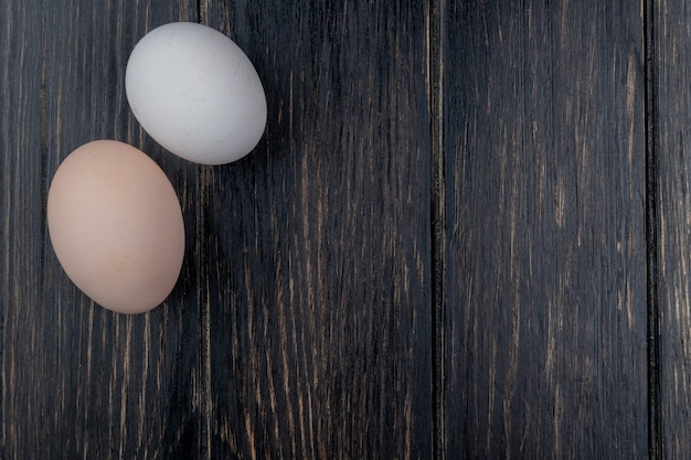 Bovenaanzicht van verse kippeneieren op een houten achtergrond met kopie ruimte